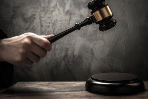 Judge's hand holding wooden hammer