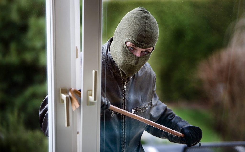 robber breaking into back door of house